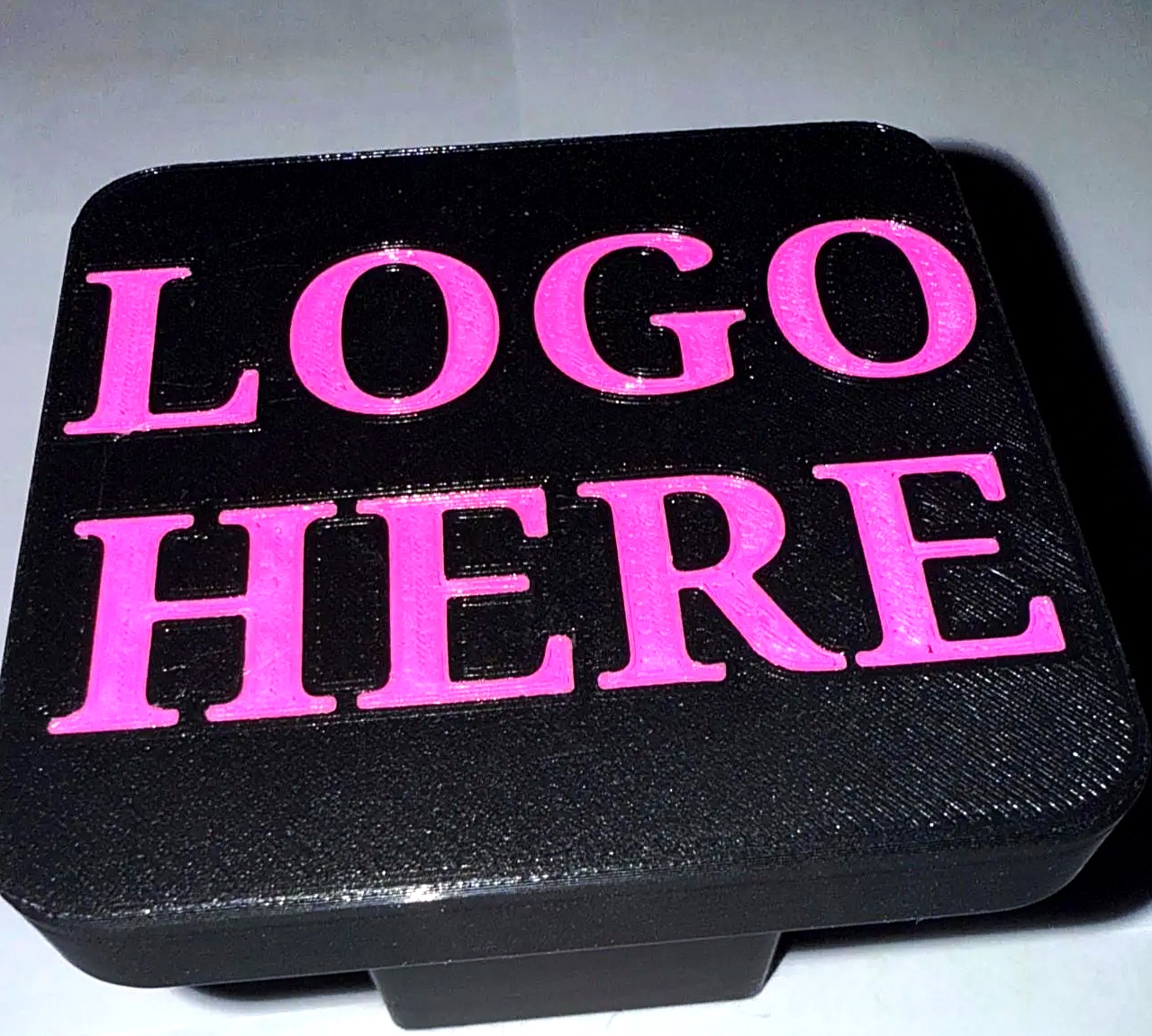 Custom 2-inch trailer hitch cover, straight-on studio photo showing the customizable logo area
